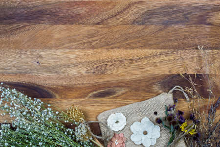 Dried wild flowers and burlap bag with wooden backgroundの写真素材