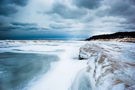 Sand dunes and frozen waves on cloudy dayの写真素材