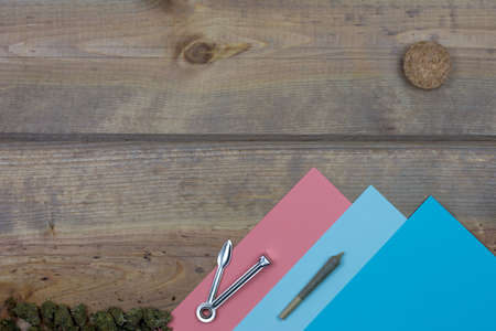 Colorful mountains and cork sun with cone shaped joint, metal cleaning tool and weed buds against rustic wood texture surfaceの写真素材