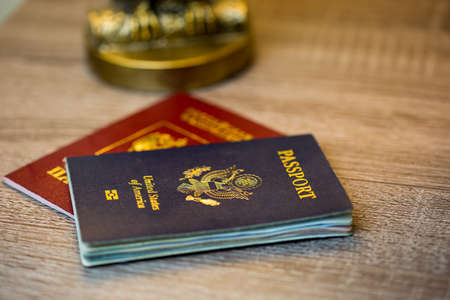United States passport with Russian passport on wood surface and golden lamp base in backgroundの写真素材