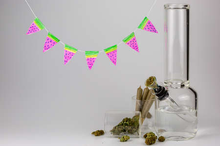Bong with weed buds, joints and hand crafted watermelon pennants against whiteの写真素材