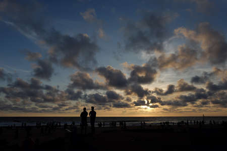 INDIA. VARKALA â MRCH 05, 2017 : Silhouettes of people watching a beautiful sunset on the beach of the Indian Ocean. Varkala town in the south of India in the state of Kerala, known for its spas.のeditorial素材