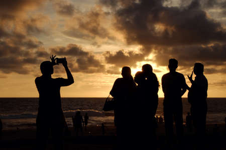 INDIA. VARKALA â MRCH 05, 2017 : Silhouettes of people watching a beautiful sunset on the beach of the Indian Ocean. Varkala town in the south of India in the state of Kerala, known for its spas.のeditorial素材