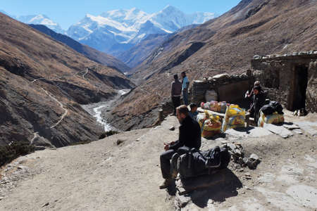 NEPAL. MANANG - NOVEMBER 16, 2016 : Tourist trekker near a small shop high in the mountains on the trail around Annapurna. Manang largest alpine tourist town on the Annapurna Circuit.のeditorial素材
