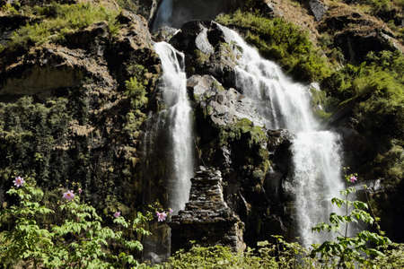 Waterfall in the mountains in Nepal among green plantsの写真素材