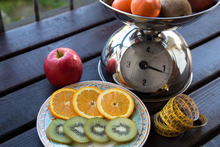 Fresh fruits on a wooden table with a measuring tape in the backgroundの写真素材