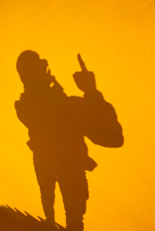 Silhouette of a man with a camera on a yellow backgroundの写真素材
