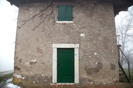 Old house with green door and window on a foggy winter dayの写真素材