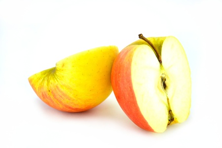 halves of fresh bright red and yellow apples on a light background freeの写真素材