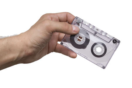 Man hand with an old audio cassette isolated on white backgroundの写真素材