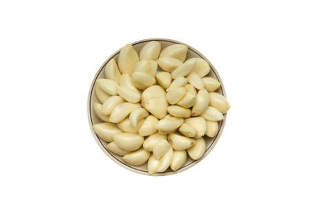 Peeled garlic on a round plate isolated on white backgroundの写真素材
