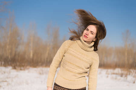 Beautiful woman in a winter forest with flying hair.の写真素材