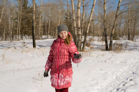 Woman in pink taking selfie on a winter sunny day.の写真素材