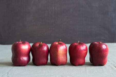 Five red apples on a grunge background