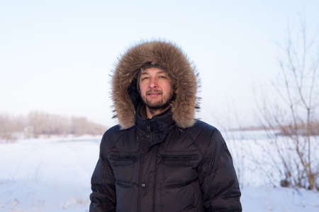 Portrait of a young man in warm clothes outdoorsの写真素材