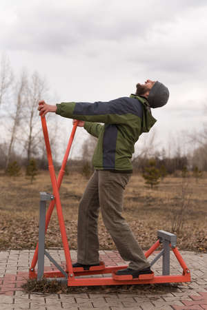 Man with a beard exercising outside in spring