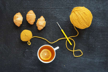 Crocheted element, lemon tea and biscuits on a grunge background.の写真素材
