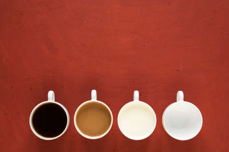 Four cups on a red background. One is with black coffe, one is with coffee and milk, one is with...