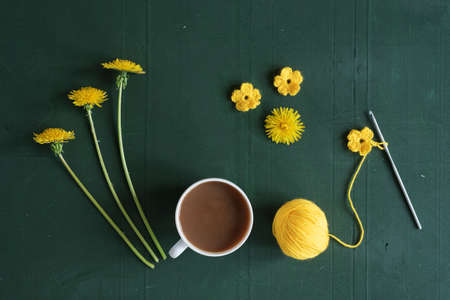 Coffee, crocheting and dandelions on a red shabby background.の写真素材