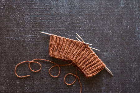 Brown knitting on a black grunge background.の写真素材