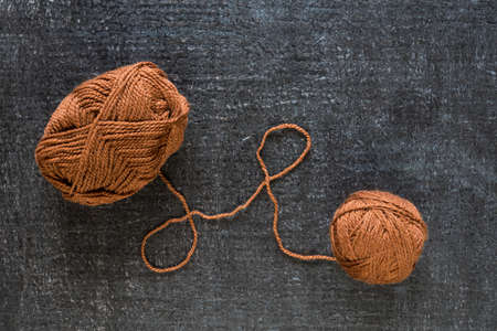 Brown yarn on black grunge background shot from above.の写真素材