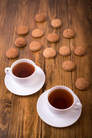 Tea and oaten cookies on a wooden tableの写真素材