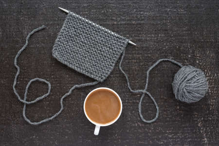 Grey knitting and coffee on black backgroundの写真素材
