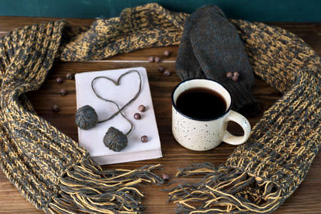 Winter still life with coffee, scarf and book on a wooden tableの写真素材