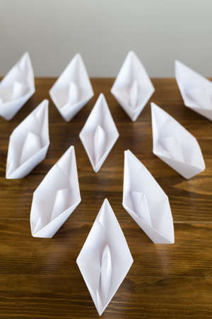 Origami paper boats on a wooden tableの写真素材