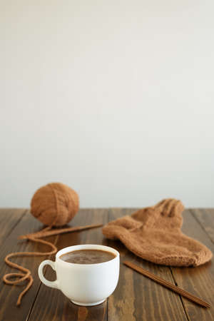 Coffee, woolen sock and knitting on a tableの写真素材