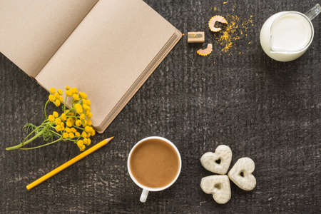 Diary with coffee, flowers and cookies on blackの写真素材