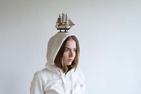Portrait of a woman with a toy ship on her headの写真素材
