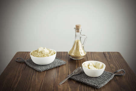 Millet porridge and butter on a wooden table. Manipulated soft image, vignette is added.の写真素材