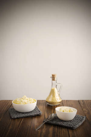 Millet porridge and butter on a wooden table. Manipulated soft image, vignette is added.の写真素材