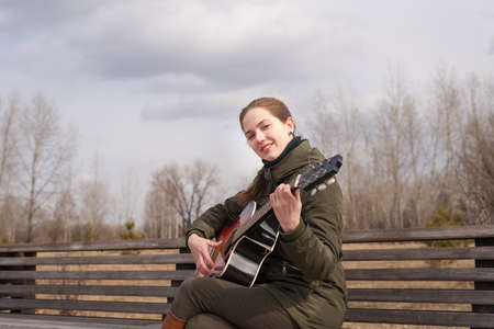 Smiling woman playing the guitarの写真素材