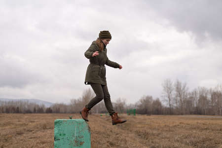 Young hipster woman jumping from a concrete blockの写真素材