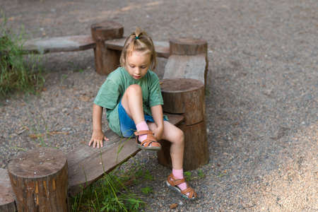 Little girl putting on her sandalの写真素材