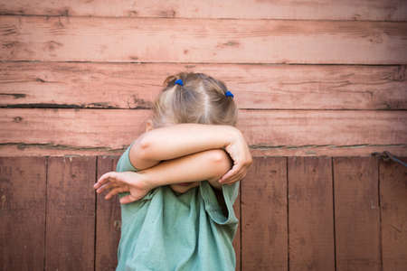 Little girl covering her face with armsの写真素材