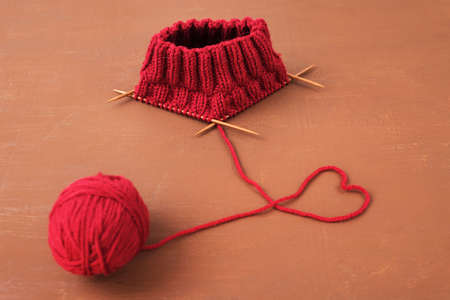 Dark red knitting on a brown grunge background.の写真素材