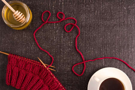 Composition with coffee, honey and red knitting on a black background.の写真素材