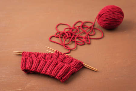 Dark red knitting on a brown grunge background.の写真素材