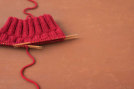 Dark red knitting on a brown grunge background.の写真素材