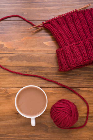 Coffee and red knitting on wooden backgroundの写真素材