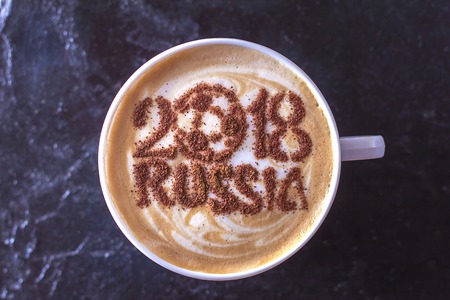 A cup of coffee with foam and powder in the shape of a soccer ball.(series)の写真素材