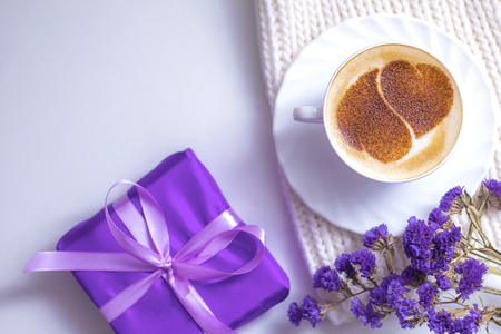 morning of a teenage girl with cappuccino and heart in a mint cup with a tablet computer and a camera on a white background in flowersの写真素材