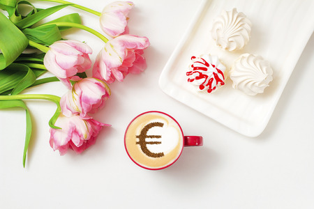 cup of coffee cappuccino with a picture of a Euro sign from cinnamon on milk foamの写真素材