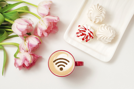 A cup of cappuccino coffee with painted cinnamon on milk foam with a wi-fi symbolの写真素材