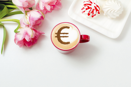 cup of coffee cappuccino with a picture of a Euro sign from cinnamon on milk foamの写真素材