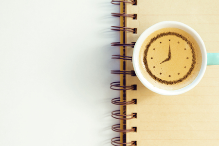 a cup of coffee cappuccino with a clock pattern from cinnamon on milk foamの写真素材