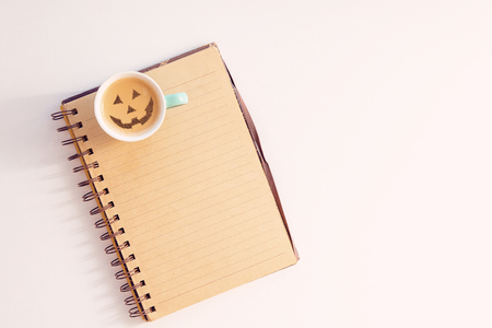 a cup of cappuccino coffee with a picture of a halloween symbol from cinnamon on milk foamの写真素材